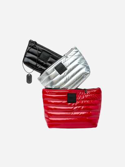 Three quilted travel bags in black, silver, and red on a white background