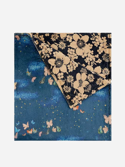 Floral patterned  reversible blanket on a blue background with butterfly designs