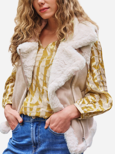 Woman wearing a yellow plaid shirt with a white fur-trimmed jacket on a white background