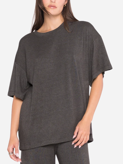 Person wearing a dark gray oversized t-shirt on a white background