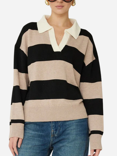 Woman wearing a black and beige striped sweater with a white collar on a white background