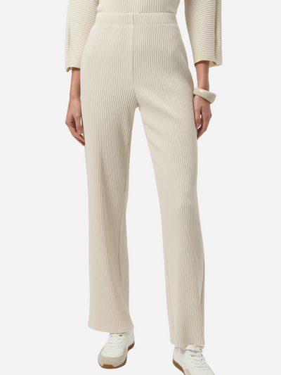 Person wearing a cream ribbed knit pants on a white background
