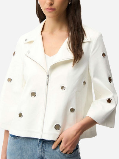 White jacket with grommet details worn by a woman on a white background