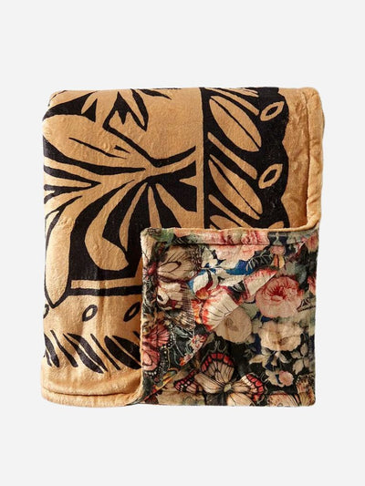 Folded REVERSIBLE blanket with black floral pattern on a beige background