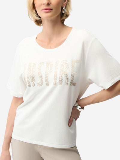 Woman wearing a white t-shirt with gold text design on a plain background