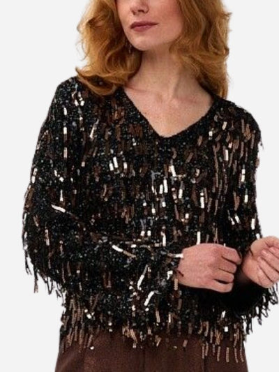 Woman wearing a black sequin top  with fringe with a plain background