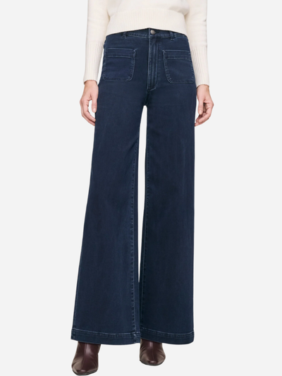 Person wearing dark blue wide-leg jeans on a white background