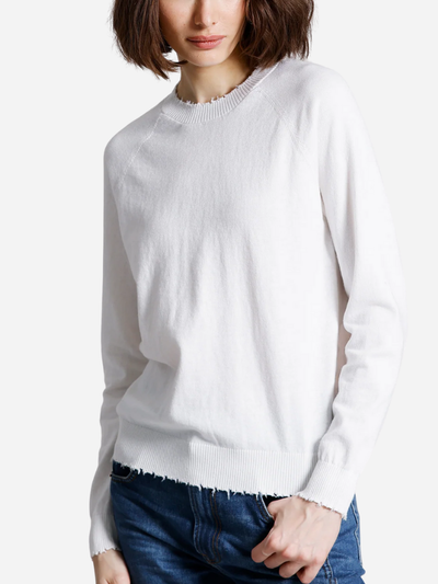 Person wearing a white sweater and blue jeans on a white background