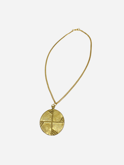 Gold necklace with a round pendant on a white background