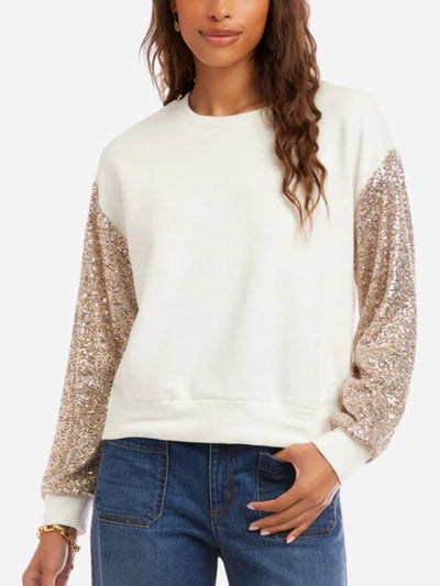 White sweater with sequin sleeves worn by a person on a white background