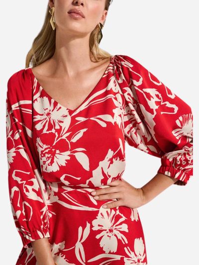 woman in red v-neck blouse with white floral print