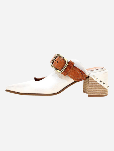 White booties with a brown strap and buckle on a white background