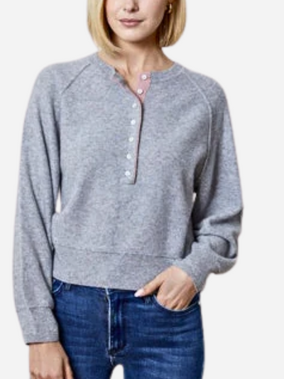 woman in gray henley sweater with pink trim