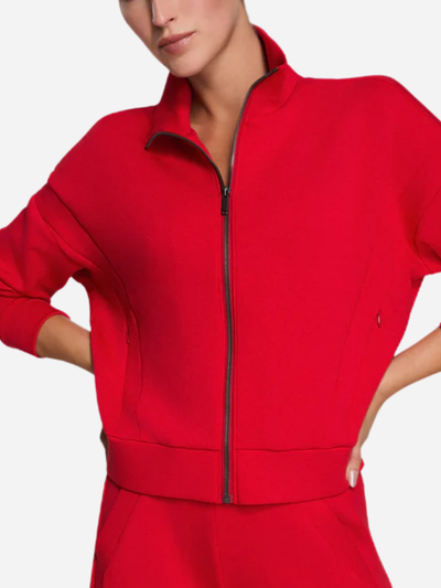 Red tracksuit worn by a person on a plain background