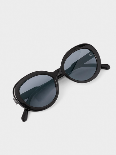 Black sunglasses with dark lenses on a light gray background