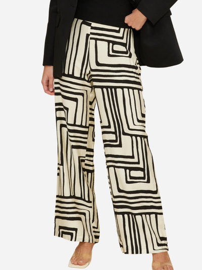 Person wearing geometric patterned pants with a plain background