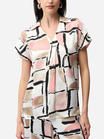 Woman wearing a short-sleeve blouse with abstract pattern on a white background