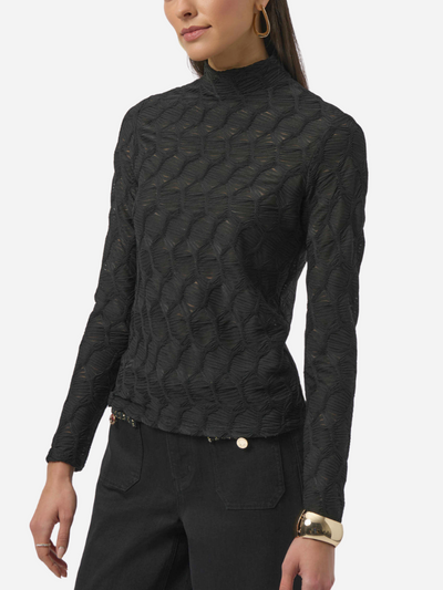Black textured long-sleeve top worn by a person on a white background