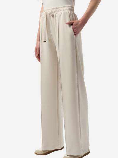 Cream wide-leg pants worn by a woman on a white background