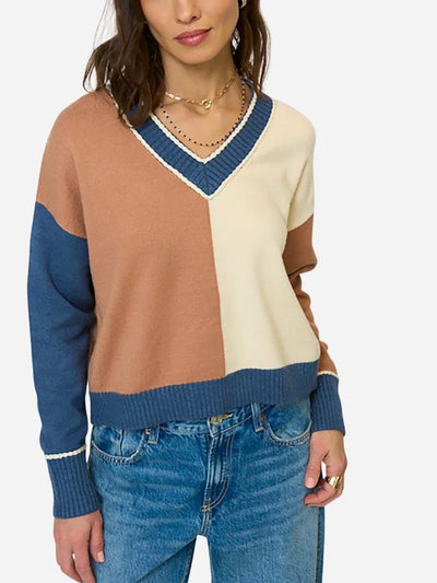 Color-blocked sweater with brown, beige, and blue sections worn by a person on a white background