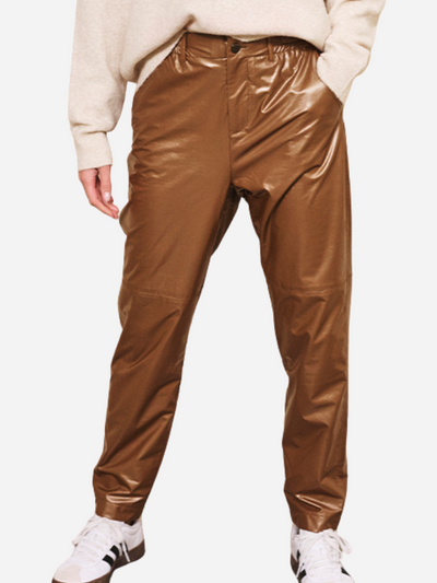 Brown metallic pants worn by a woman on a white background
