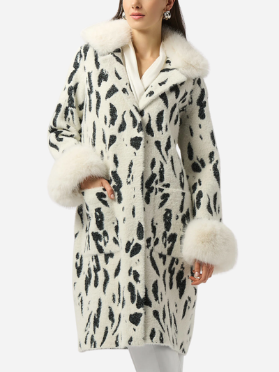 Woman wearing a white coat with black pattern and fur trim on a white background