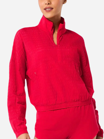 Red textured long-sleeve top worn by a person on a white background