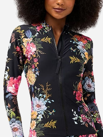 Woman wearing a black floral zip-up jacket on a white background