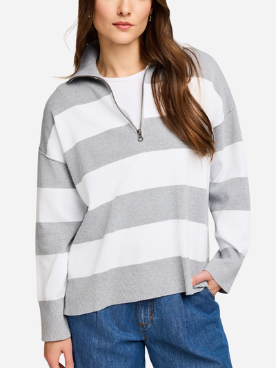 Woman wearing a gray and white striped sweater with a zipper on a white background
