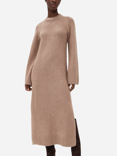 Beige sweater dress worn by a model on a white background