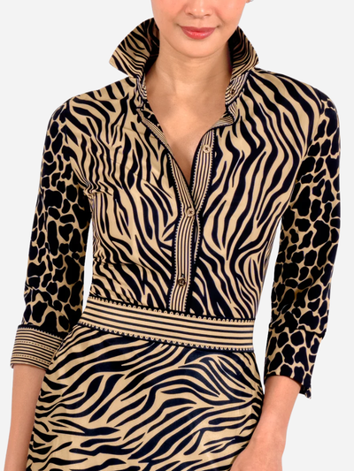 Woman wearing a dress with a zebra and leopard print pattern on a plain background