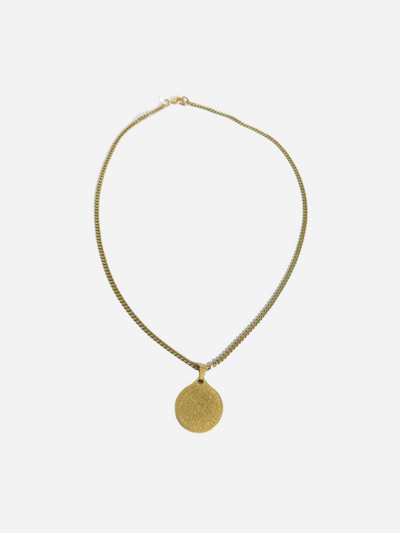Gold necklace with a round pendant on a white background