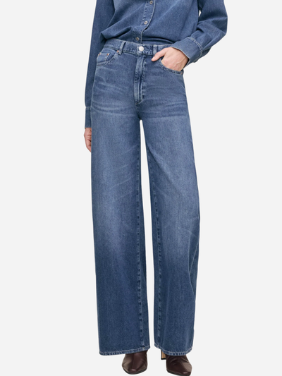 Blue denim jeans worn by a person on a white background