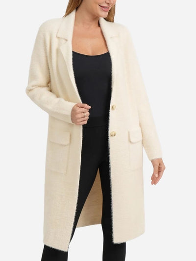 Woman wearing a long cream coat on a white background