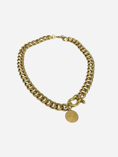 Gold chain bracelet with a round tag on a white background