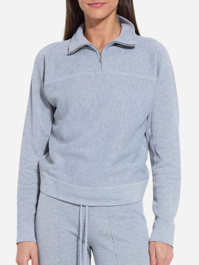 Light blue pullover with a quarter zip worn by a person on a white background