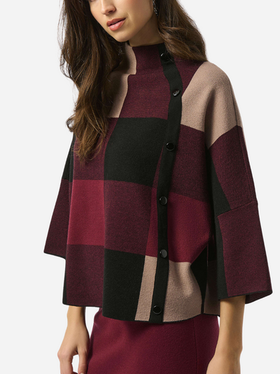 Woman wearing a plaid sweater with a neutral background