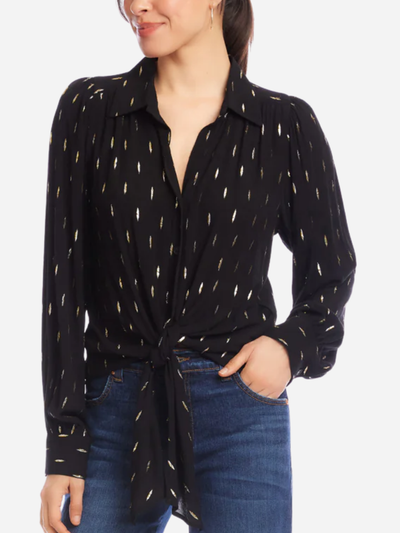 Woman wearing a black patterned shirt with a tie waist and blue jeans on a white background