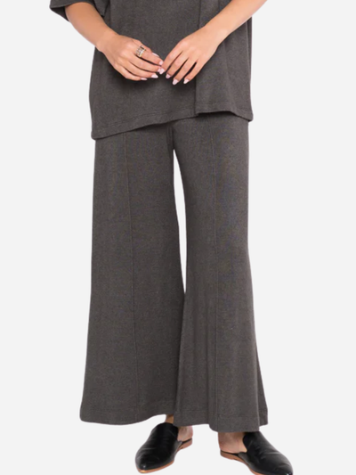 Person wearing a gray outfit with wide-leg pants on a white background